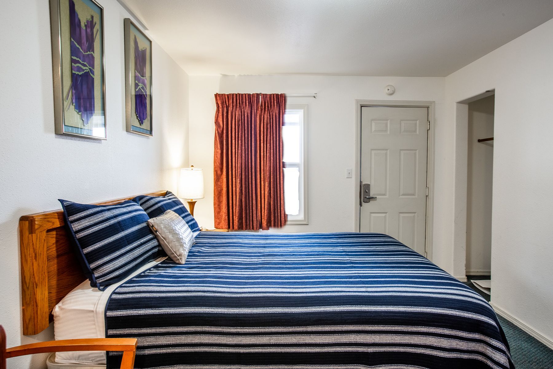 A hotel room with a king size bed and a chair.