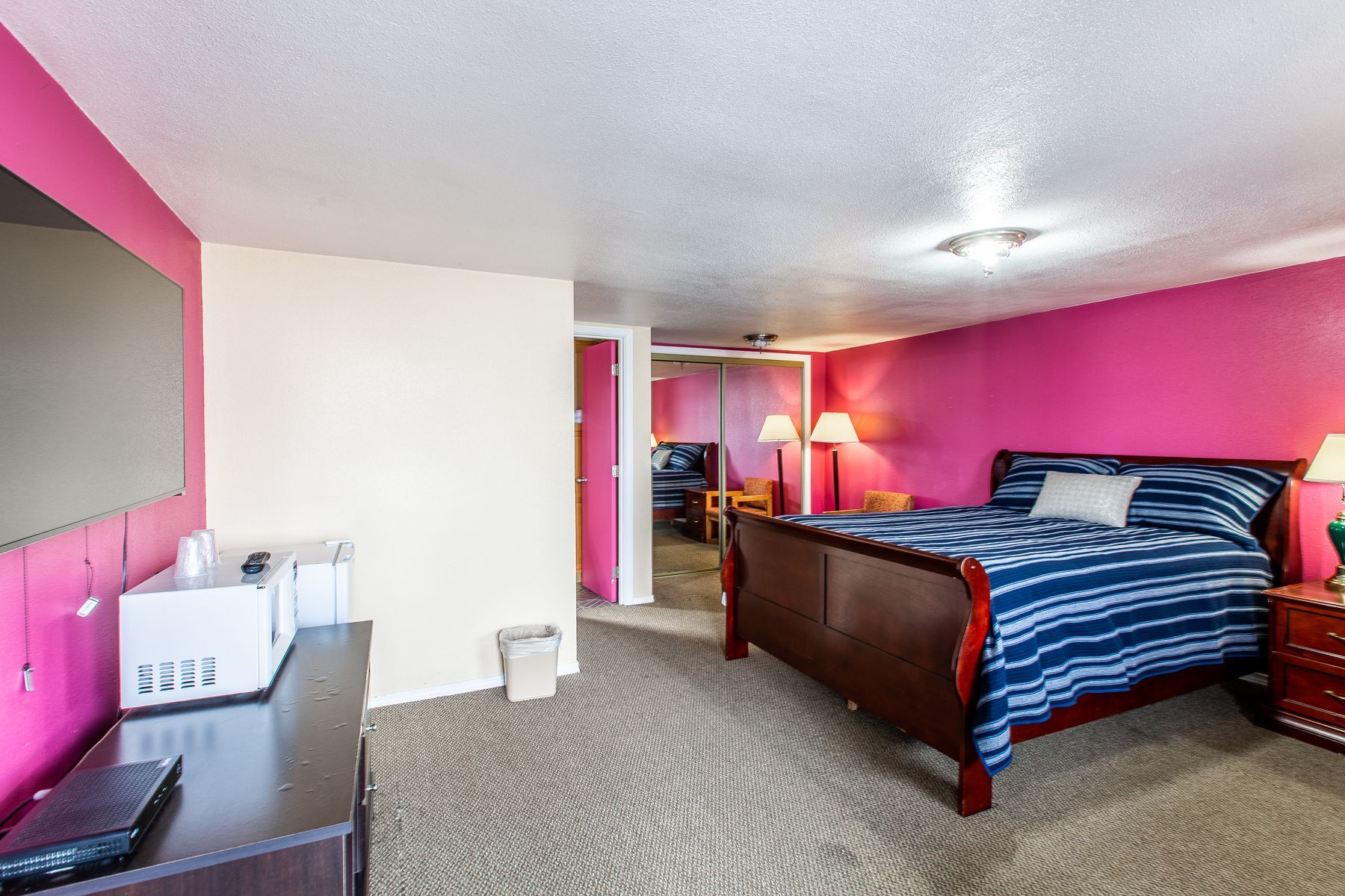 A hotel room with a king size bed and a flat screen tv.