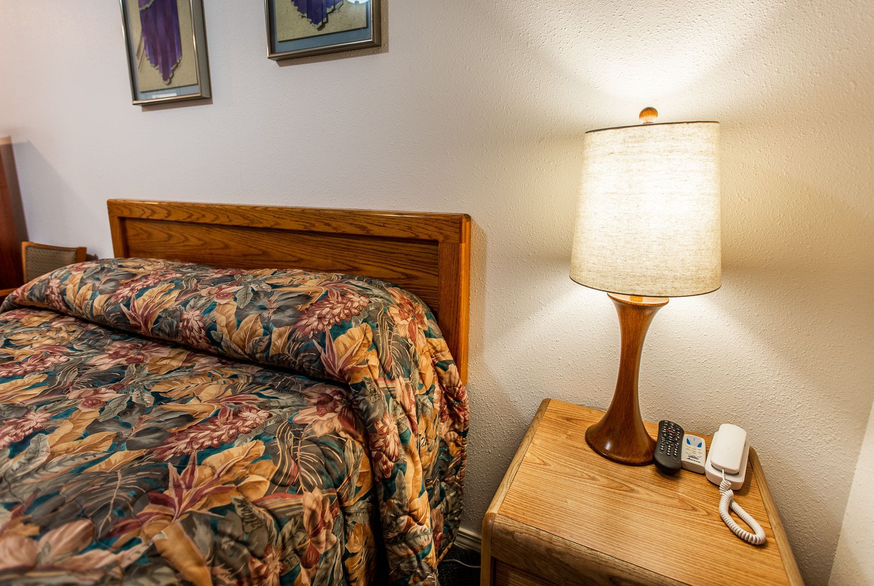 A hotel room with a bed and a lamp