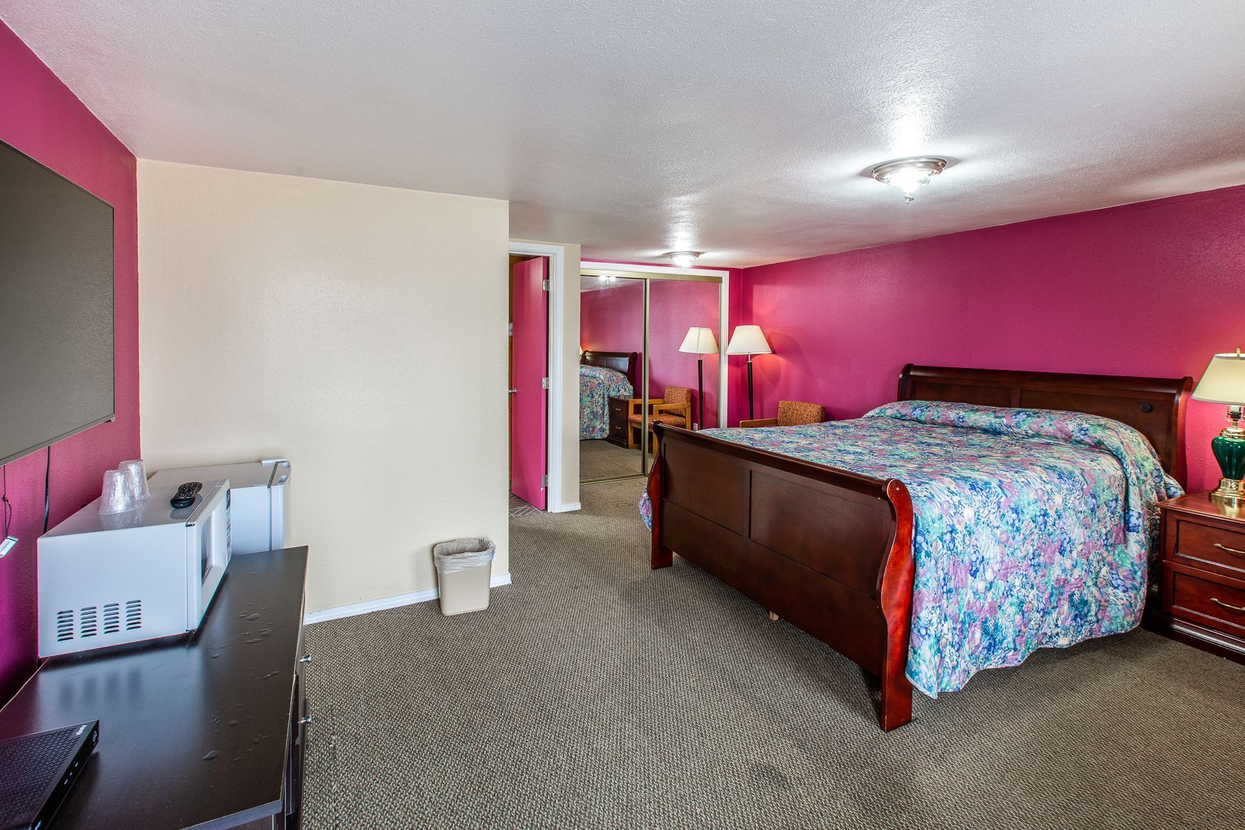 A hotel room with a king size bed and a microwave.