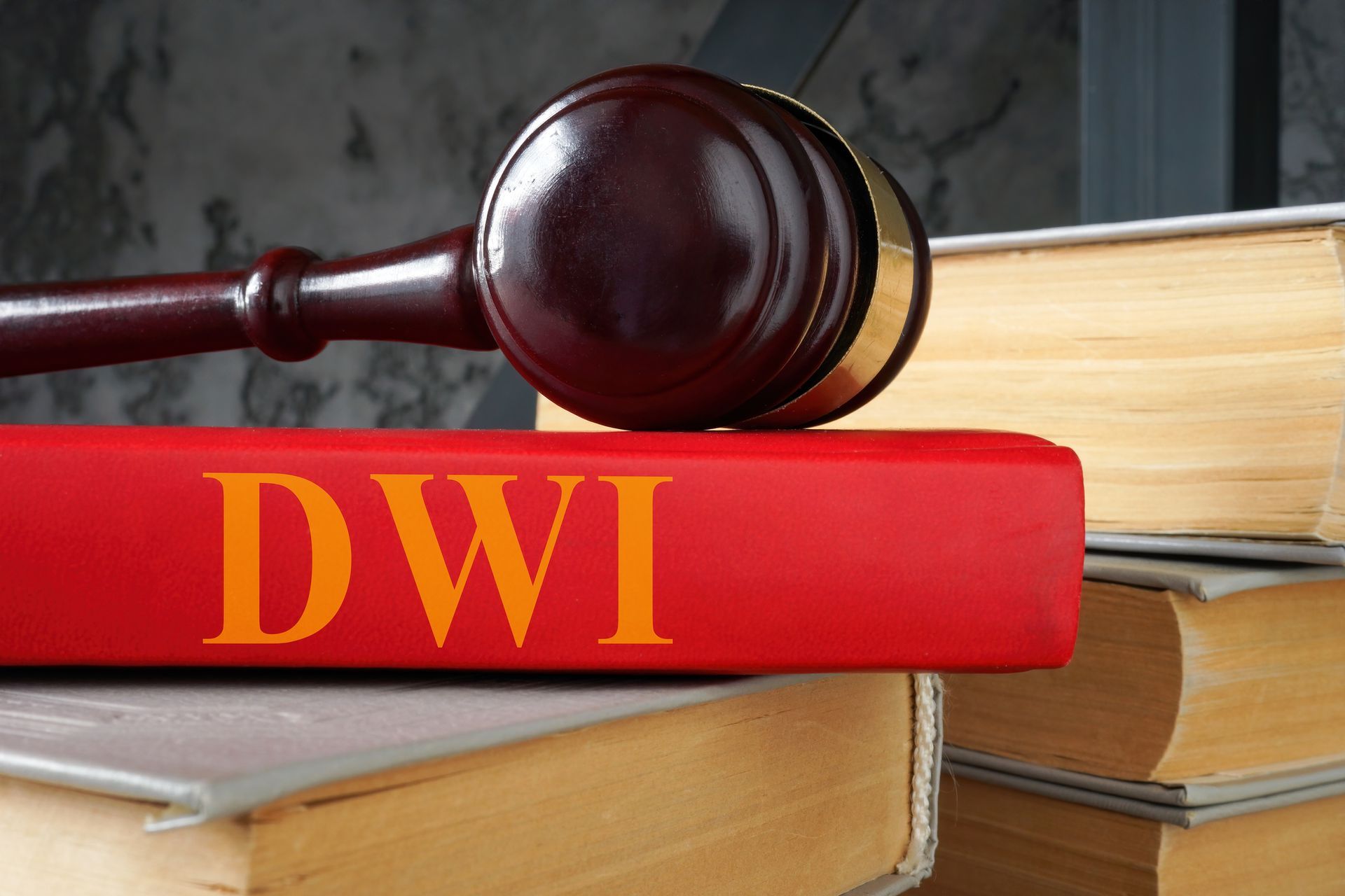 A wooden judge's gavel resting on a red book labeled 