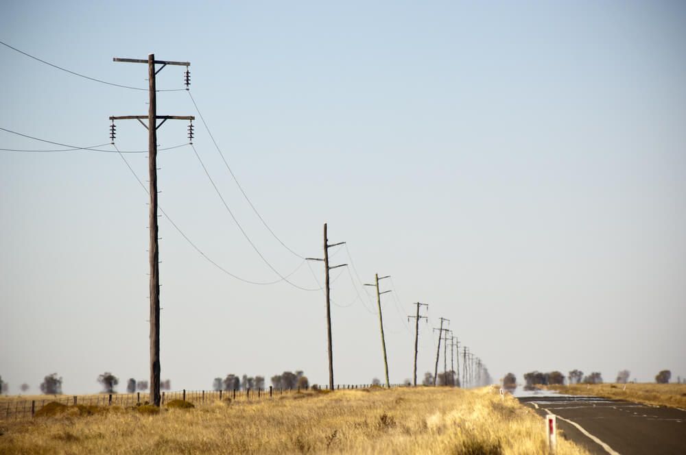 A row of power lines in the outback — Connect Mid Coast Electrical Services In Taree, NSW