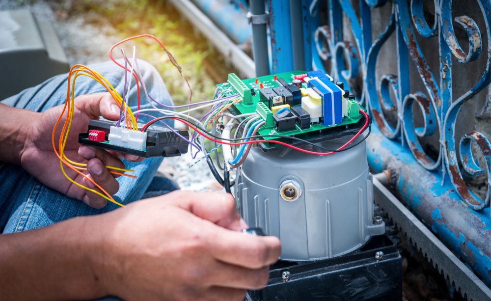 A Person Is Working On A Sliding Gate Motor — Connect Mid Coast Electrical Services In Forster, NSW