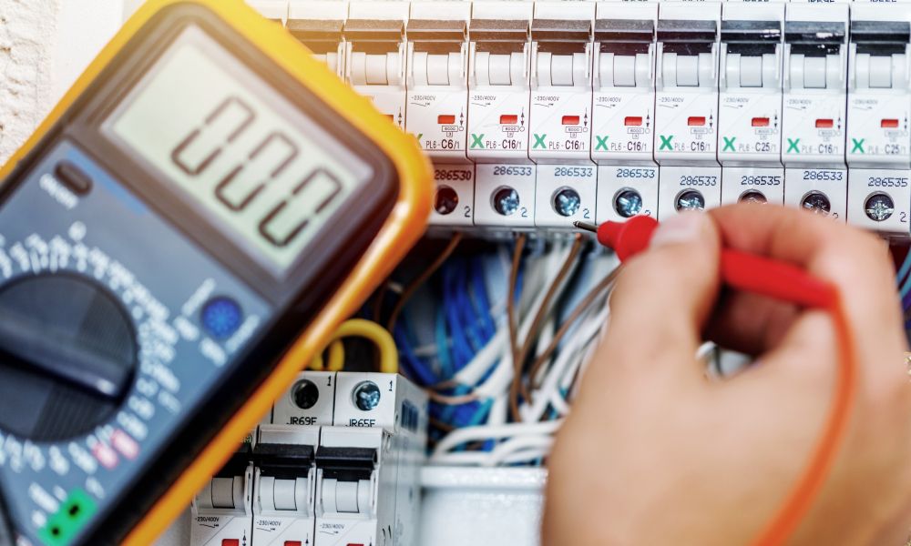 A Person Is Using A Multimeter To Test A Circuit Board — Connect Mid Coast Electrical Services In Taree, NSW