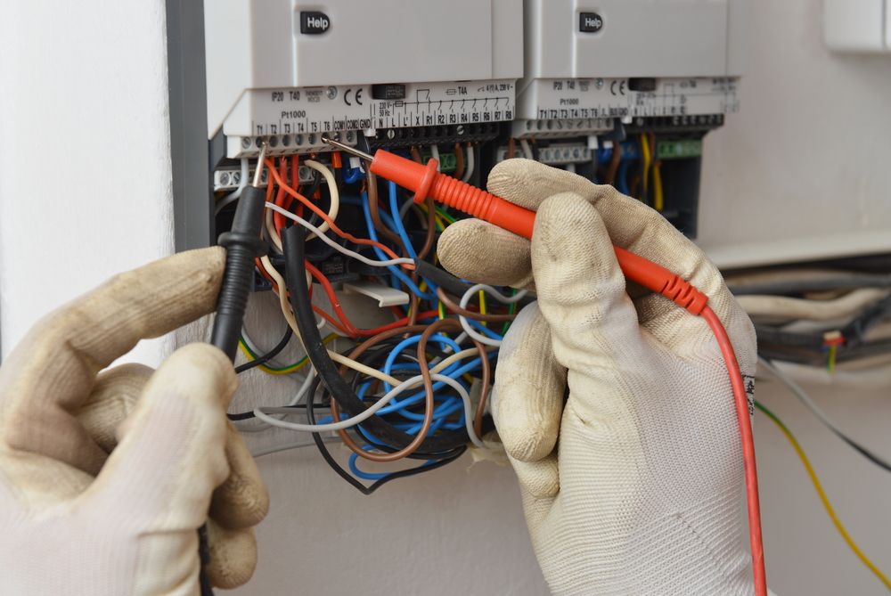 A Person Is Using A Multimeter To Test A Bunch Of Wires — Connect Mid Coast Electrical Services In Wingham, NSW