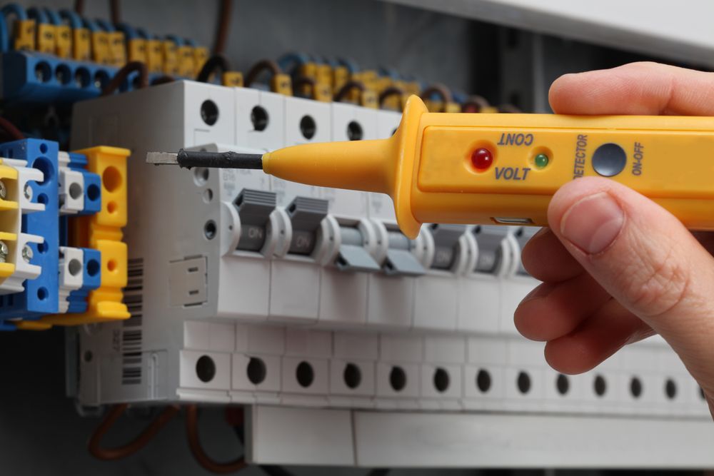 A Person Is Using A Voltmeter To Check A Circuit Board — Connect Mid Coast Electrical Services In Forster, NSW