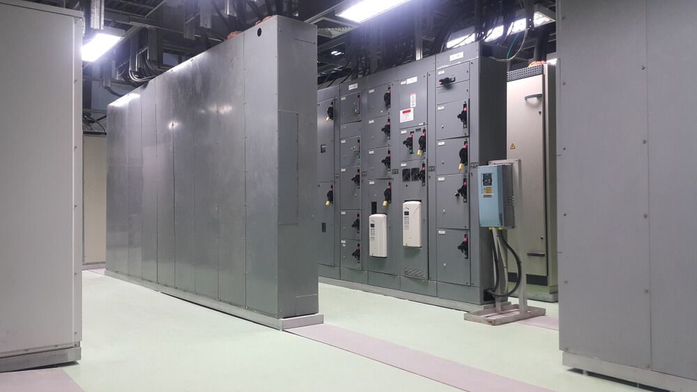 A Man Is Working On An Electrical Outlet In A House — Connect Mid Coast Electrical Services In Taree, NSW