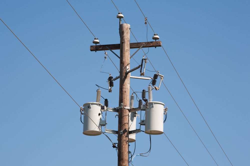 A Telephone Pole With Two Transformers Attached To It — Connect Mid Coast Electrical Services In Wingham, NSW