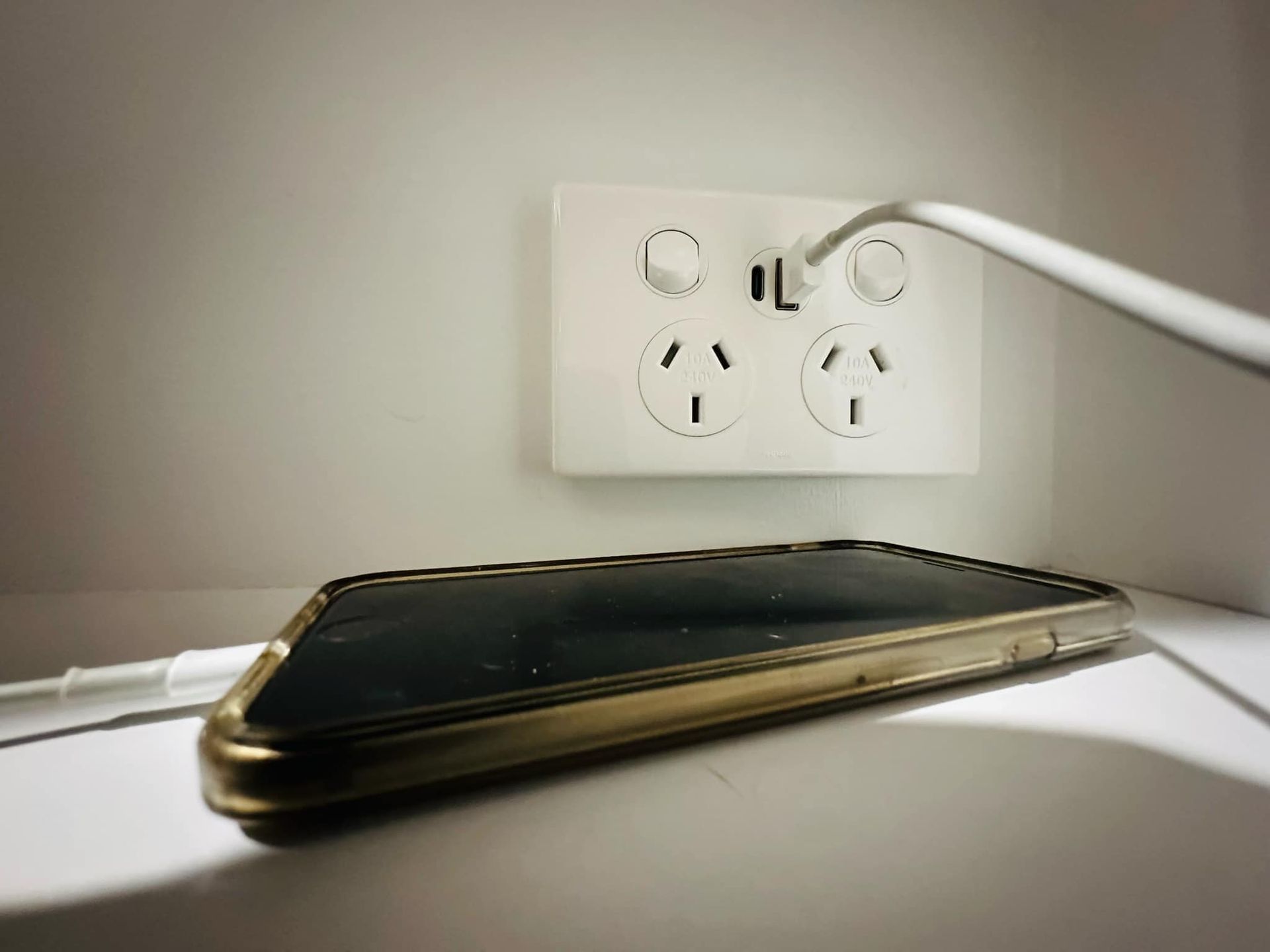A Cell Phone Is Plugged Into An Electrical Outlet — Connect Mid Coast Electrical Services In Taree, NSW