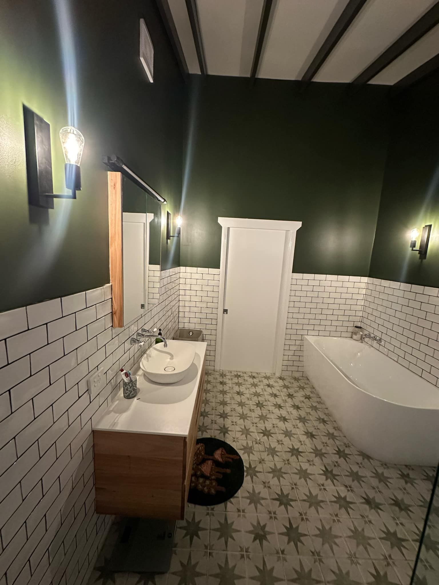 A Bathroom With A Sink, Tub, Mirror And Green Walls — Connect Mid Coast Electrical Services In Taree, NSW