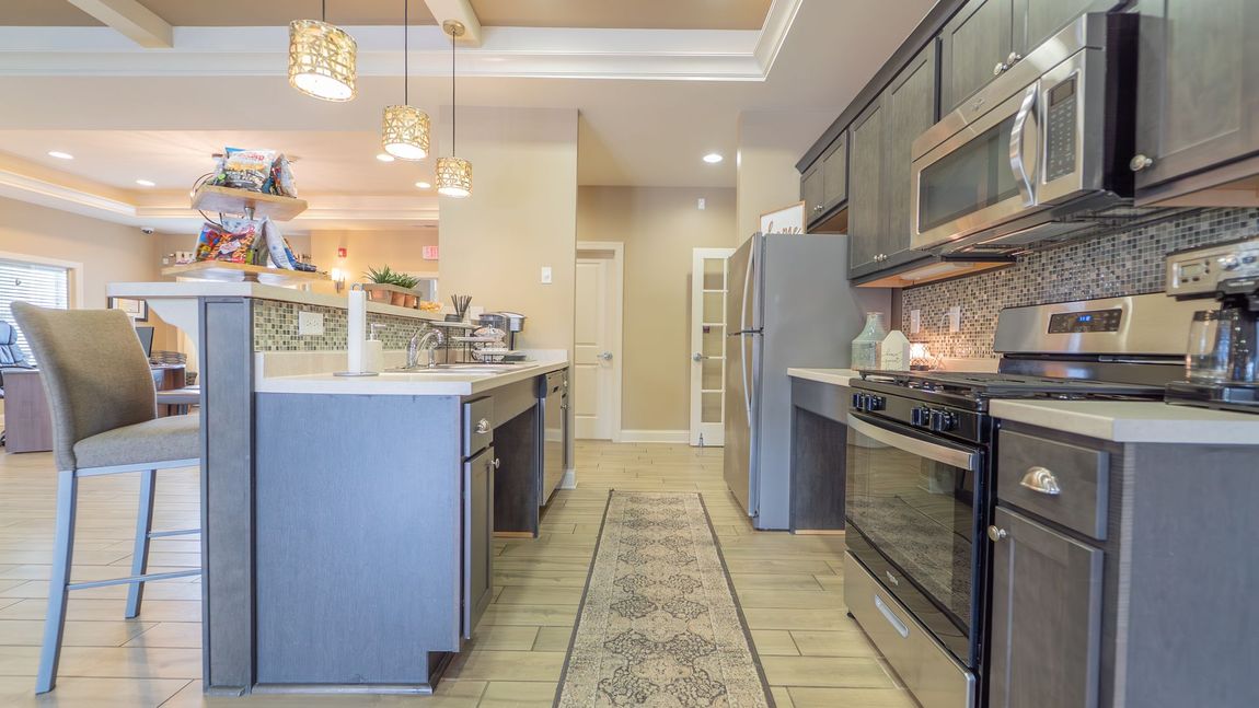 Kitchen with gray cabinets, stainless steel appliances, and a breakfast bar.