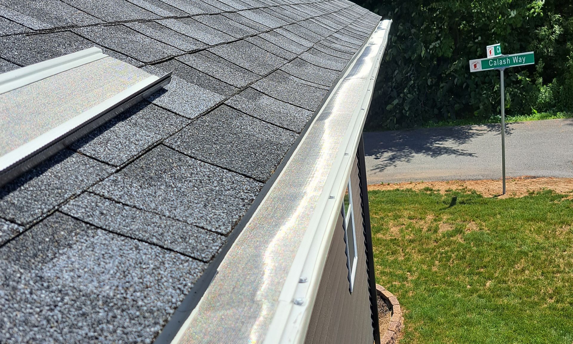 A gutter guard installation job in progress. Remaining guard lies nearby on the roof.