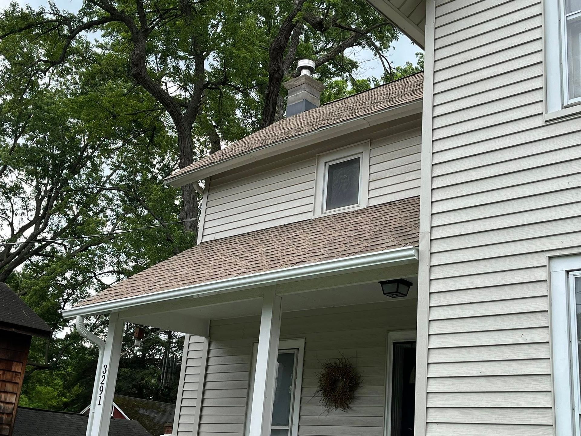 Gutters installed on a yellow house in Rochester Area