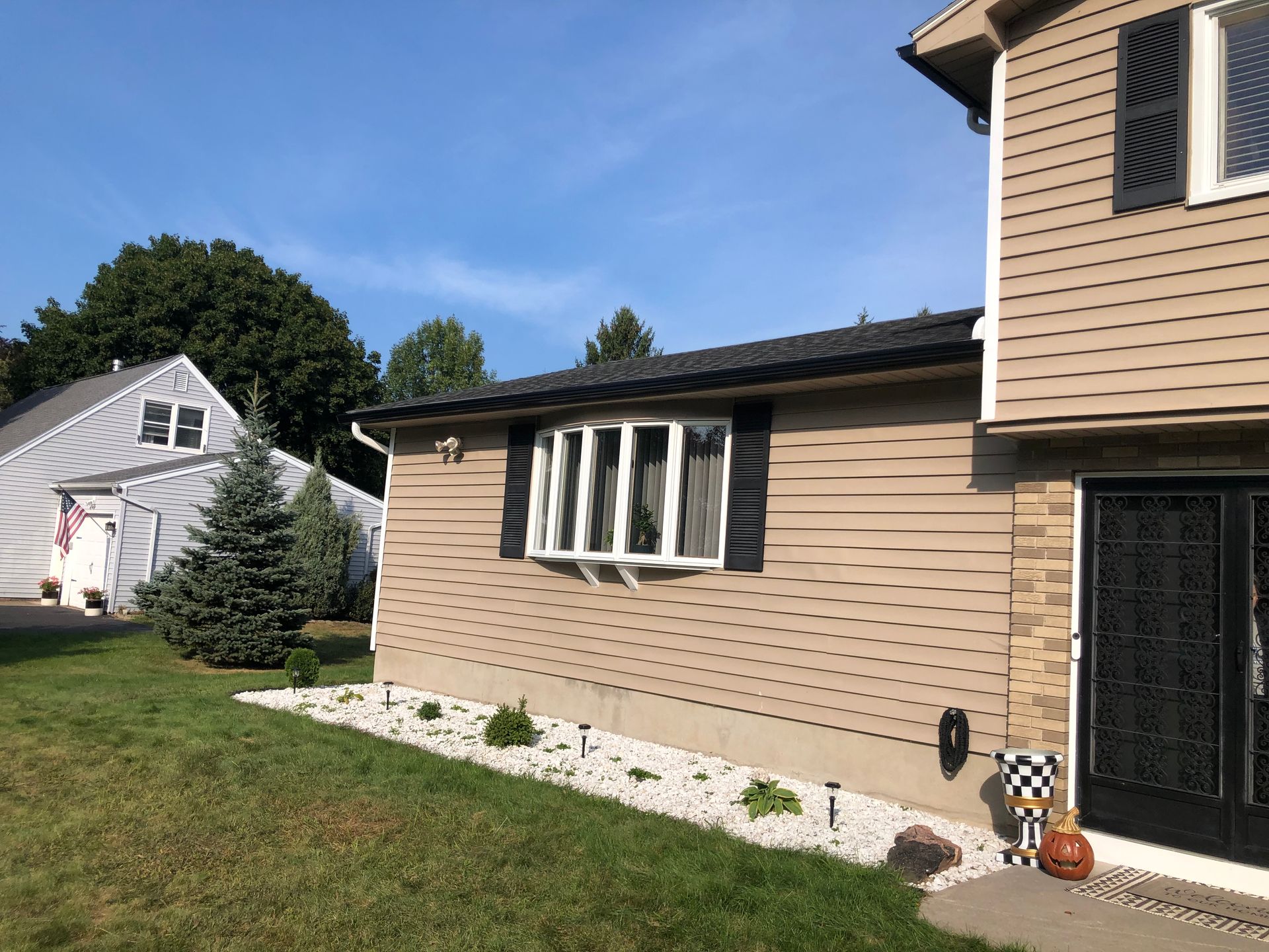 A brown house with a new downspout installed on the corner