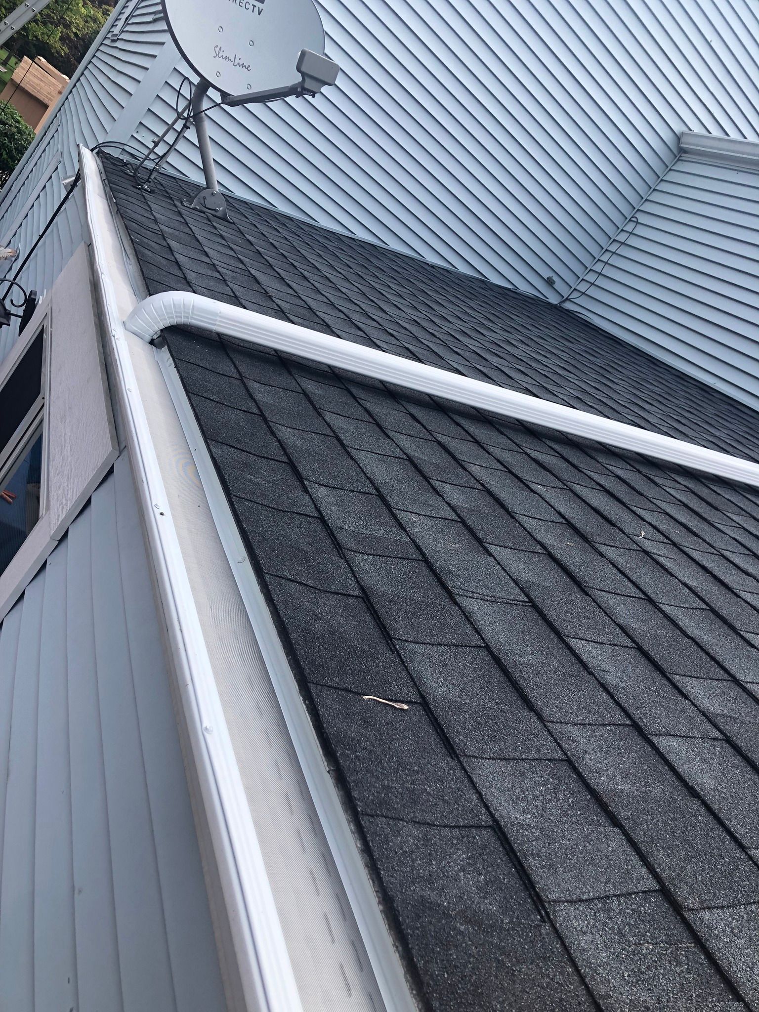 New gutter system installed on a roof seen from a side angle