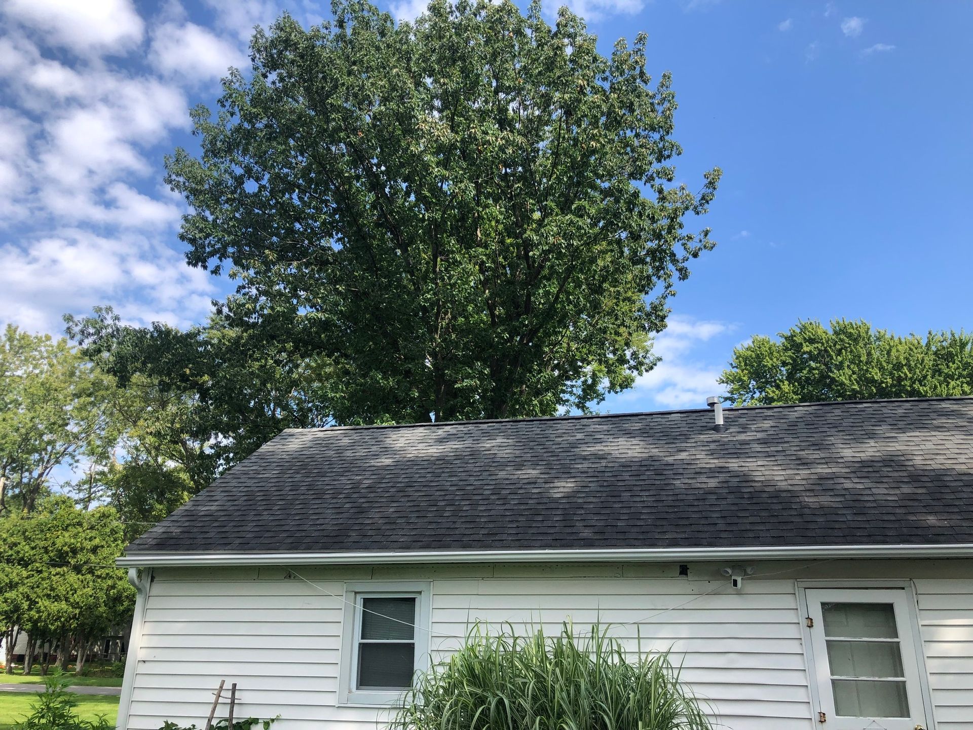 New gutters installed on a light colored house seen from a distance