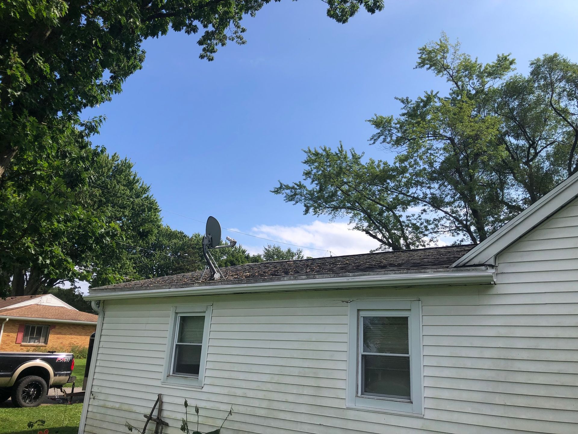 A shot of new gutter system installed on light yellow house from distance