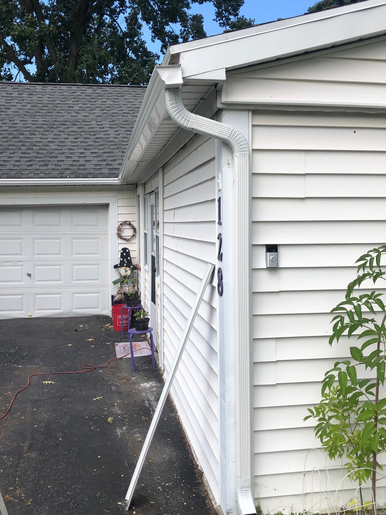 A new downspout installed on the corner of a white house
