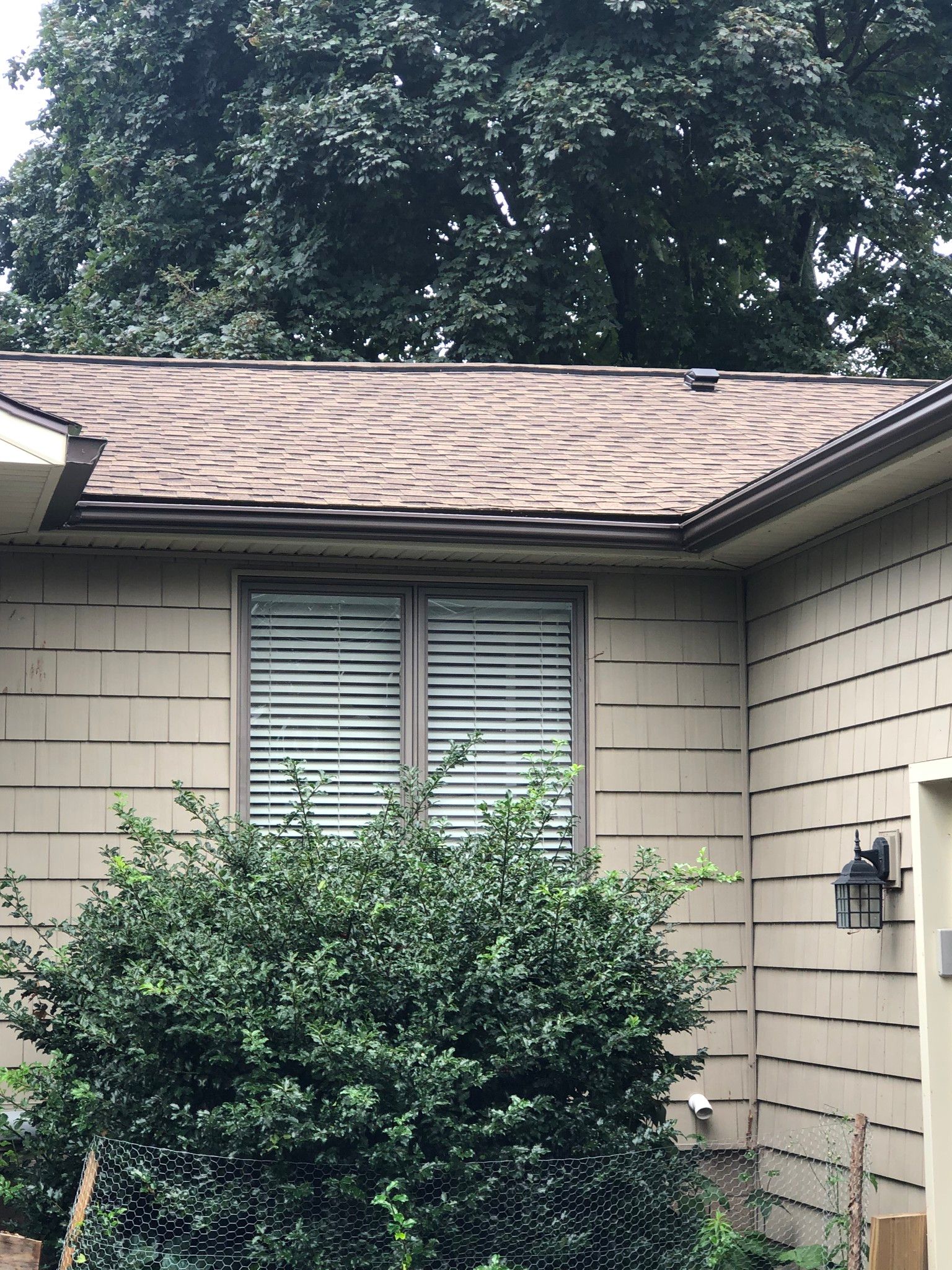 A dark brown gutter system seen after installation