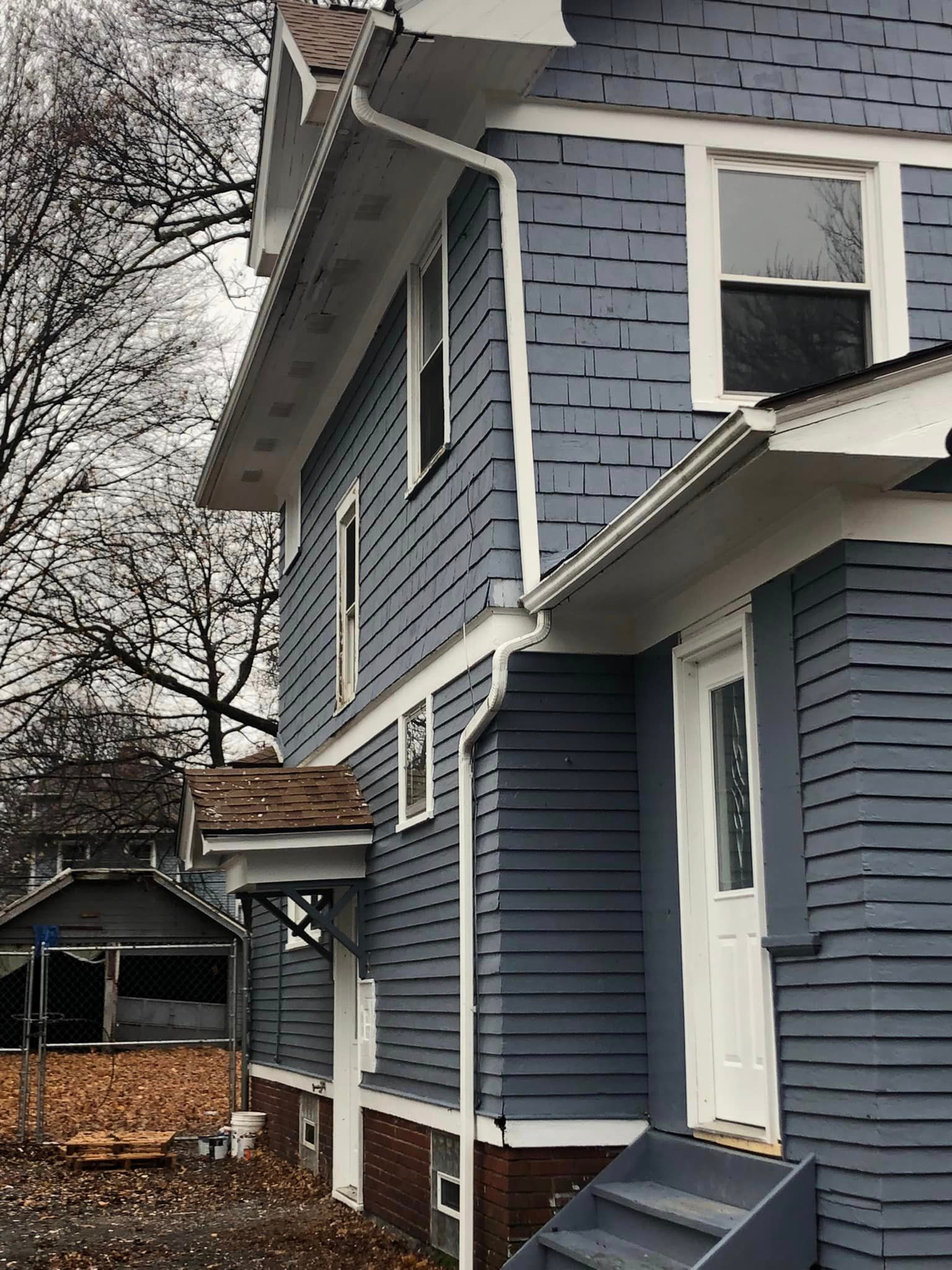 Two story gutter system installed on a dark blue house