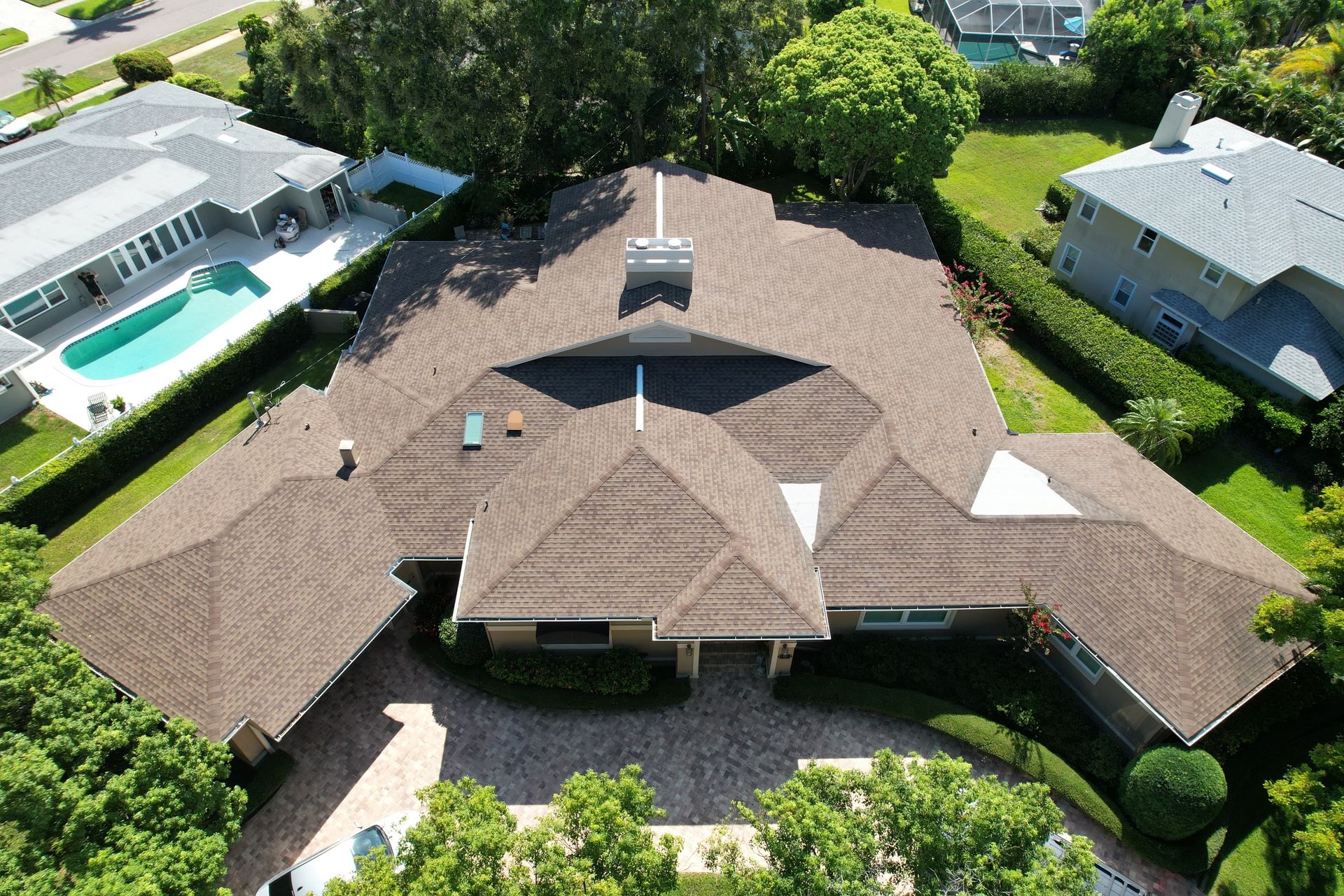 Person hammering a nail into a gray roof tile during roof construction. Person hammering a nail into a gray roof tile during roof construction.