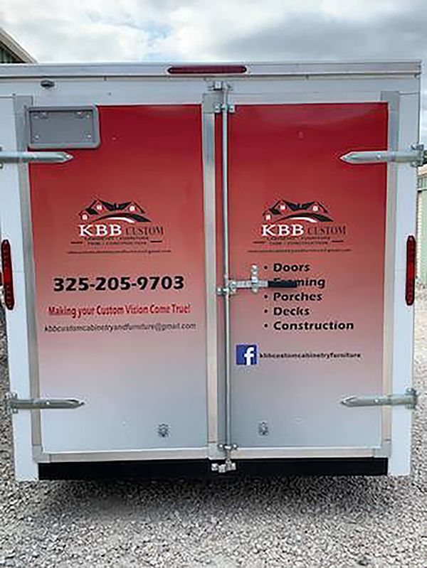 Red and silver KBB Dumpster door with company logo, phone number, and services listed.