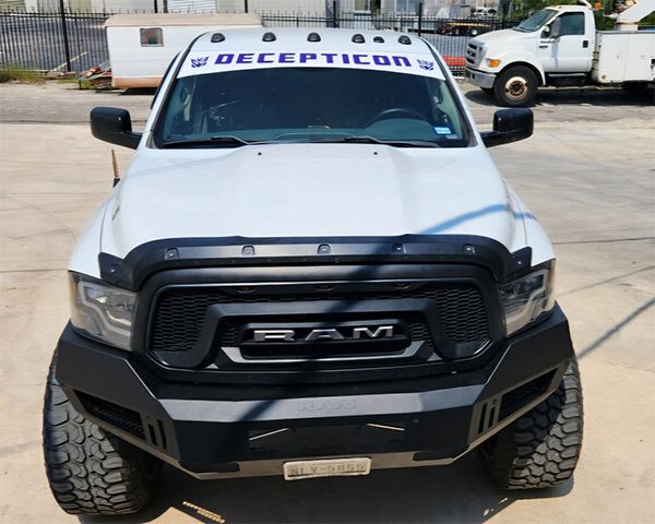 White RAM pickup truck with black grille and “DECEPTICON” decal, parked outdoors on pavement.