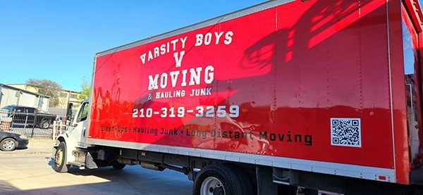 Red moving truck with “University Boys Moving” logo parked in a lot