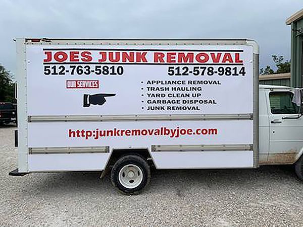 White Joe’s Junk Removal truck with red logo, phone numbers, and website on the side.
