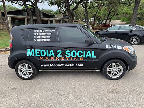 Black Media 2 Social marketing van parked outdoors with company logo and website on the side