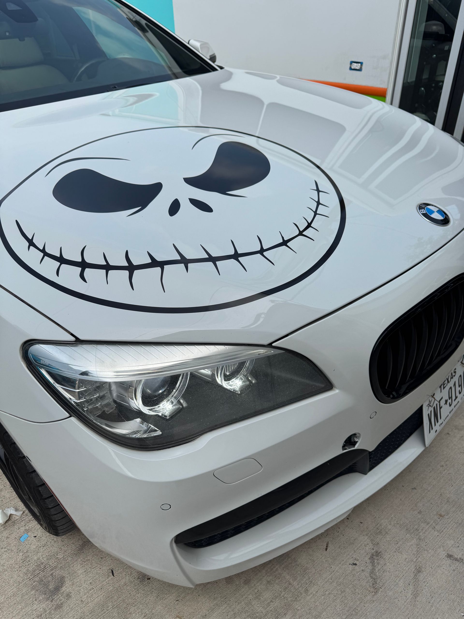White BMW hood with a large Jack Skellington face decal, close-up view.