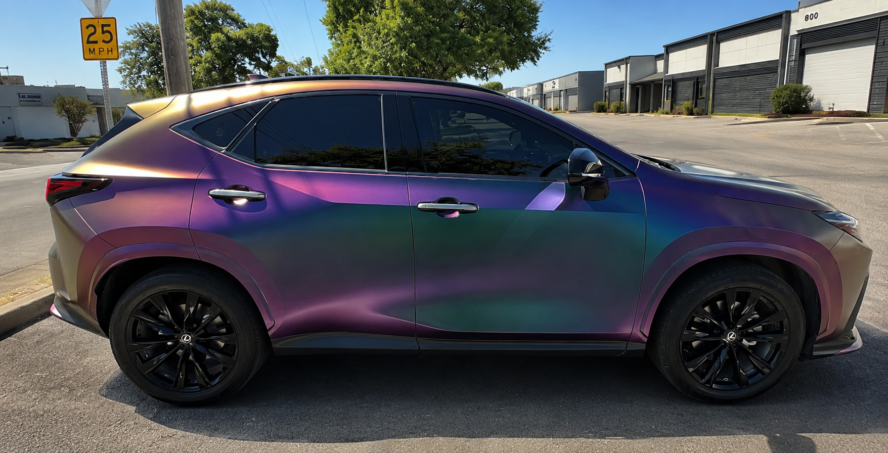 Purple-to-teal iridescent SUV parked on a sunny street, side view