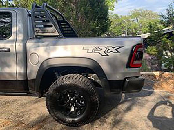 Gray Ram TRX pickup truck parked on a dirt path with trees in the background