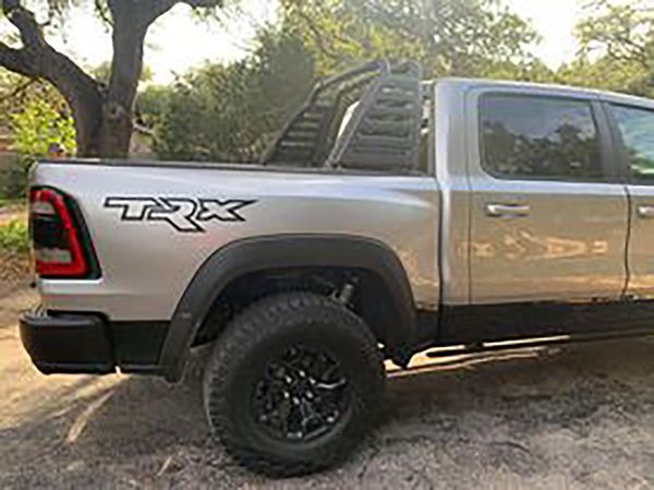 Gray Ram TRX pickup truck parked on a dirt path with trees in the background
