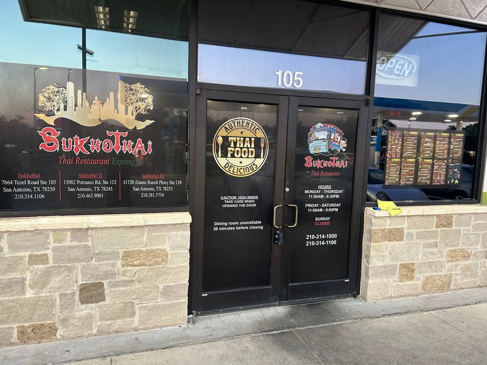 Storefront with black double doors, stone facade, and address 105 above the entrance.