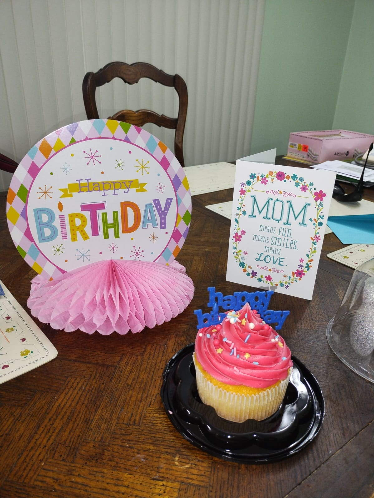 Birthday celebration with cupcake, decorations, and a card that reads 