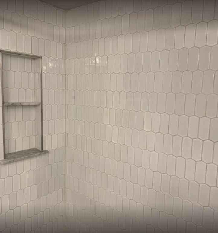 White tiled bathroom shower wall with a recessed window shelf.