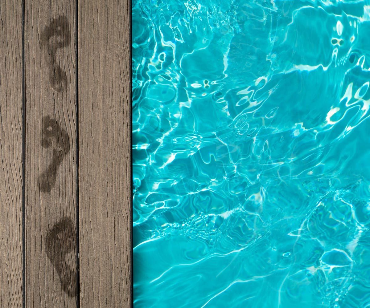 Wooden dock beside bright turquoise pool water with rippling reflections