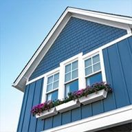 Blue house exterior with white trim and flower boxes beneath windows