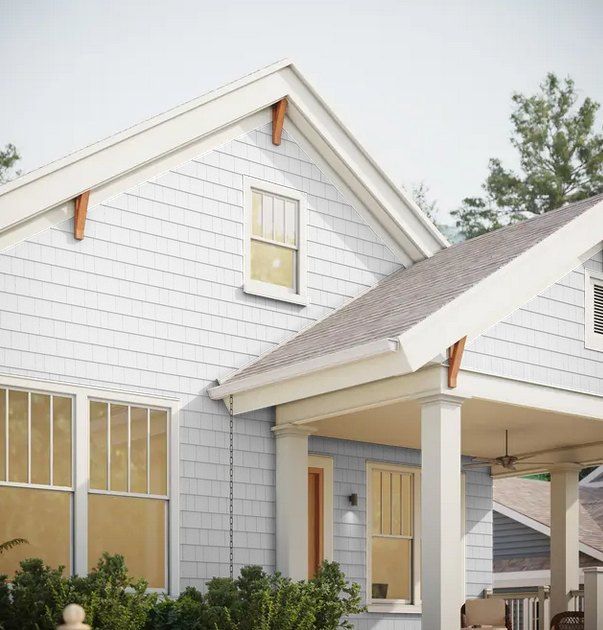 White house exterior with gabled roof, front porch, and large windows