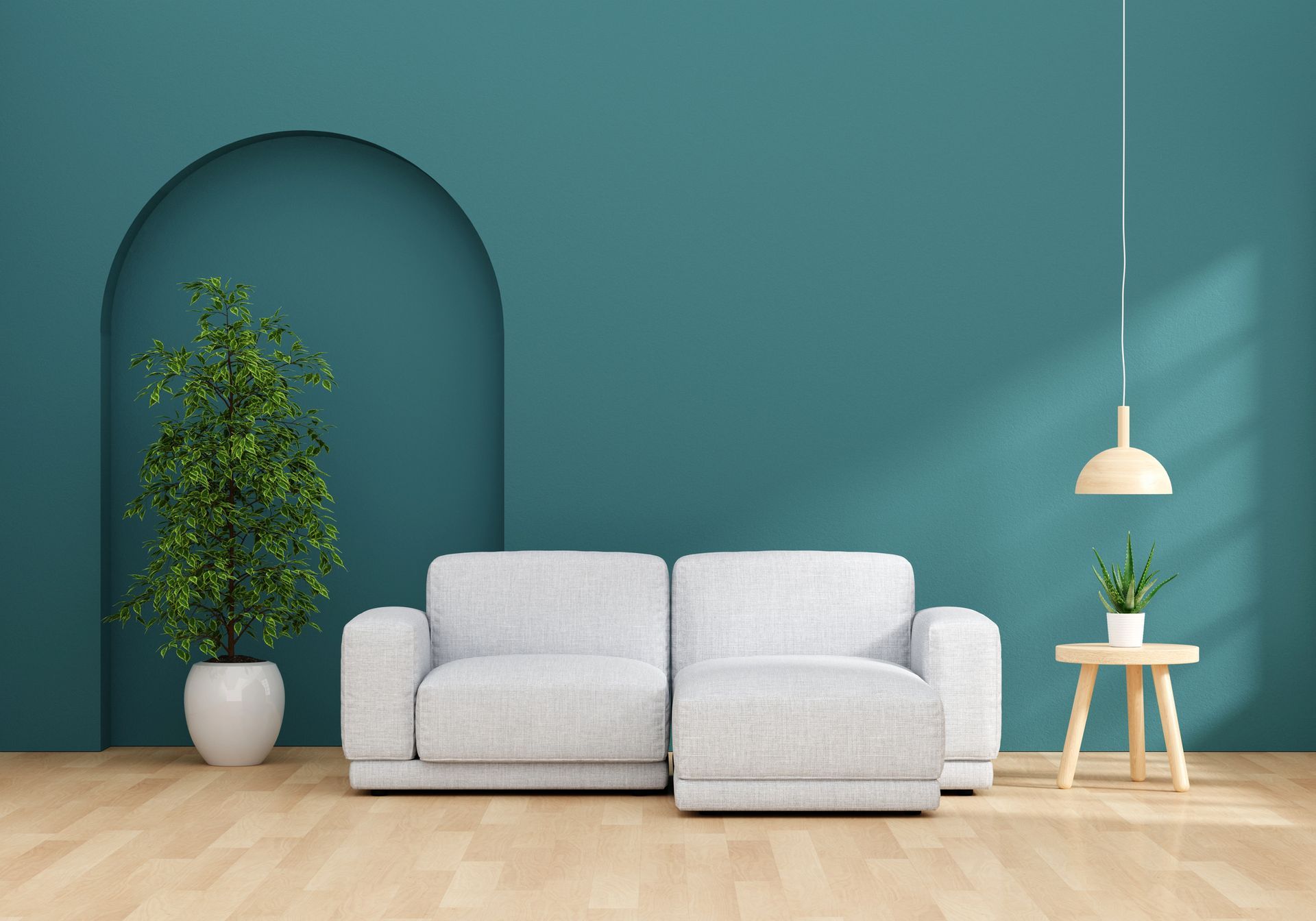 Un divano componibile bianco è posizionato su un pavimento in legno chiaro, addossato a una parete color verde acqua con un'ampia nicchia ad arco che ospita una pianta in vaso.