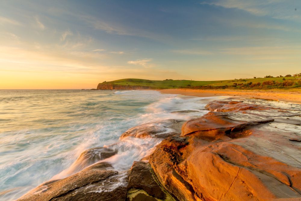 A Beautiful Sunset Over A Calm Lake, With Vibrant Orange And Pink Colors Reflecting On The Water's Surface — Sydney Underfloor Heating in Woonona, NSW