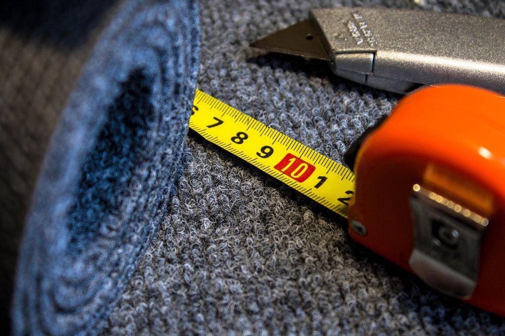 Grey Roll Of Carpet And Tape Measure — Sydney Underfloor Heating in Woonona, NSW