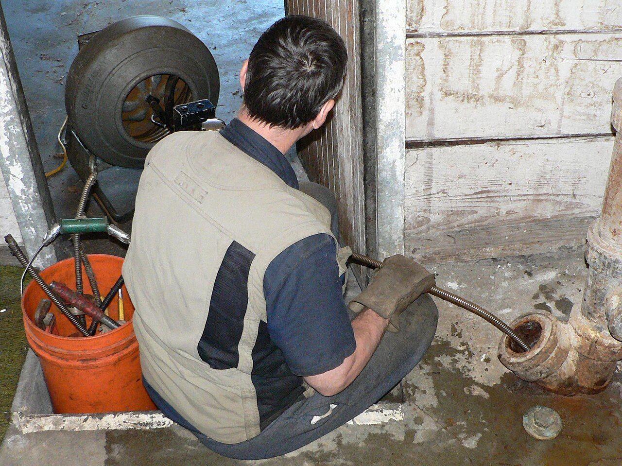 Plombier débouchant un drain avec une machine à câble (furet électrique) – Plomberie CSM