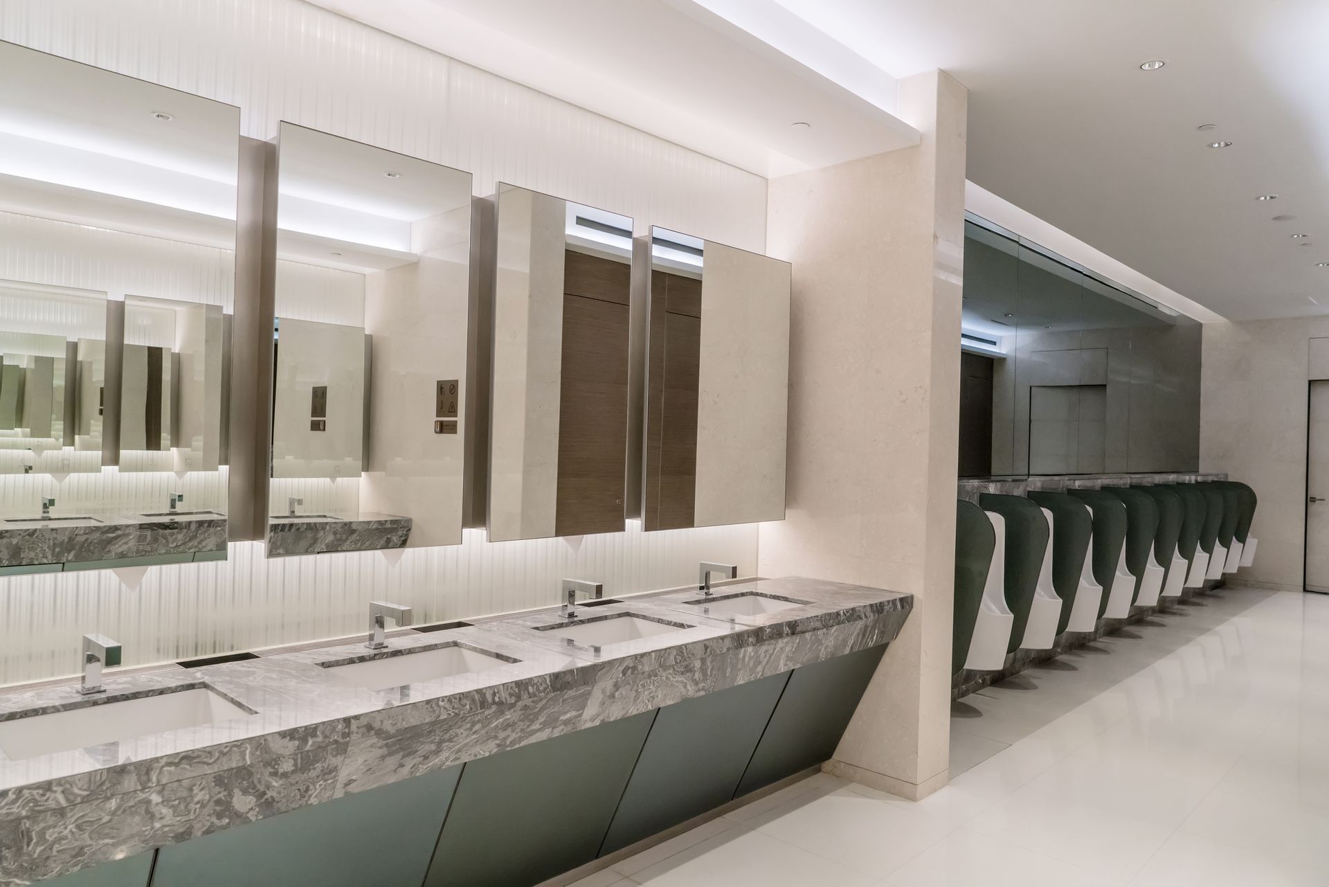 Des toilettes publiques avec beaucoup de lavabos et de miroirs.
