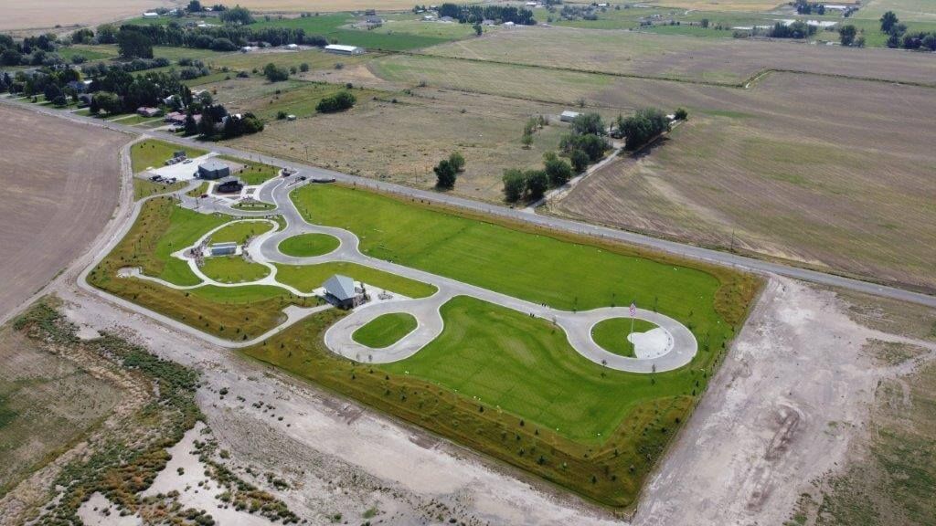 An aerial view of a grassy field with a road going through it