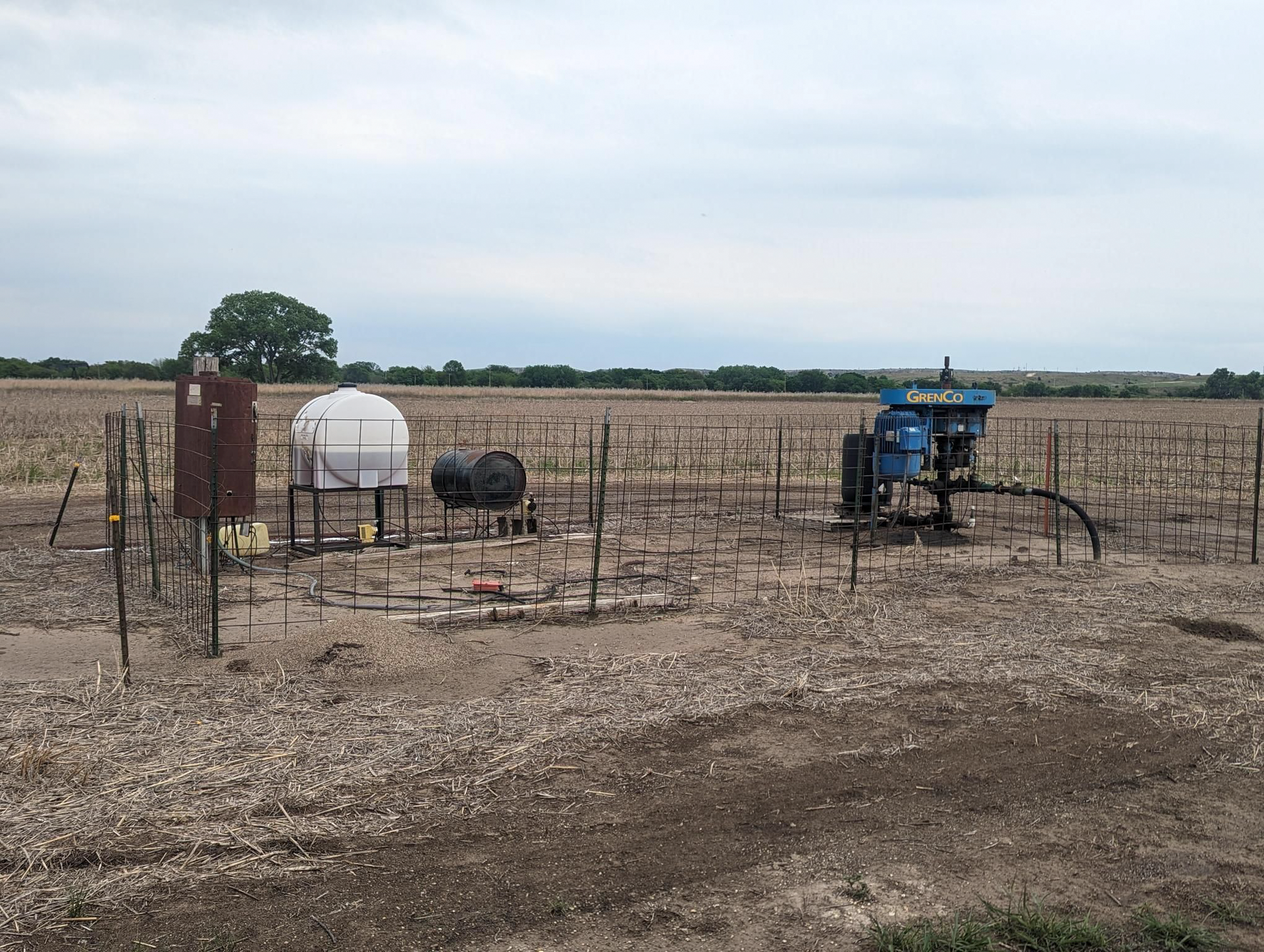 A fenced in field with a tractor in the middle of it.