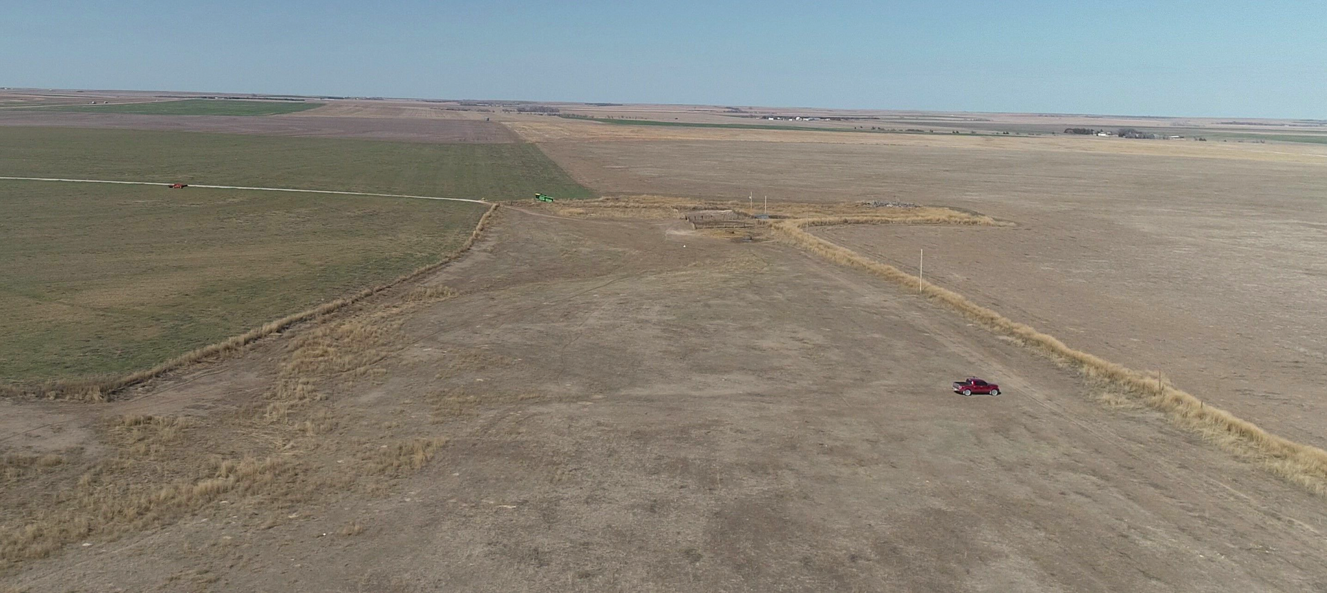 An aerial view of a dirt road in the middle of a field.