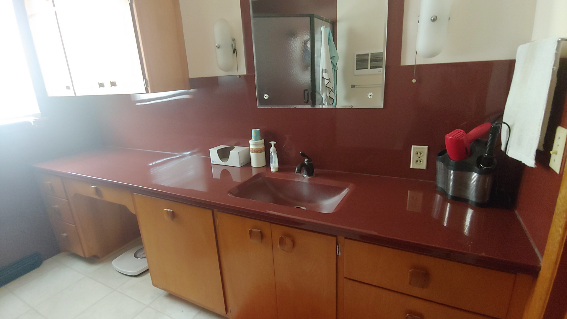 A kitchen counter with a sink and a mirror