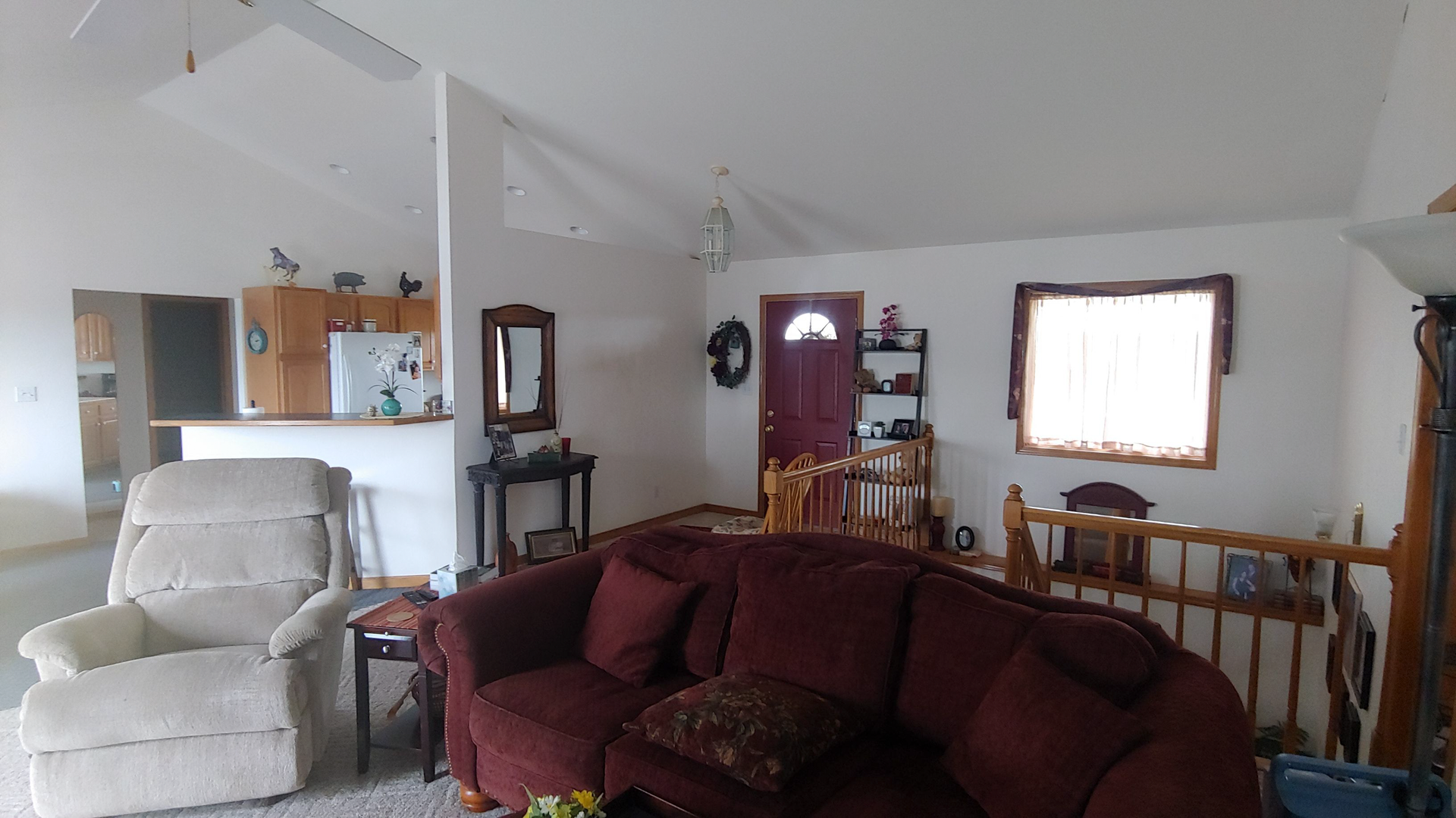 A living room with a red couch and a white chair